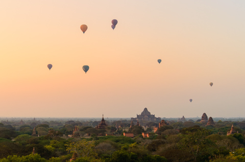 Hot air balloons drift above the ancient temples and pagodas of Bagan at sunrise, Myanmar.