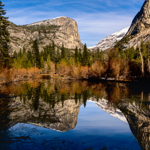 Winter reflections of Yosemite’s granite cliffs and pine trees mirrored in the calm waters of Mirror Lake.